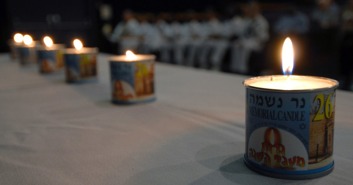 Six lit memorial candles at a remembrance ceremony