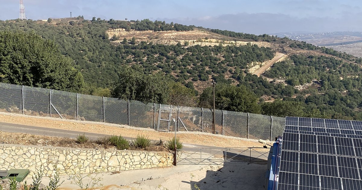 A border security fence and wooded hills in northern Israel